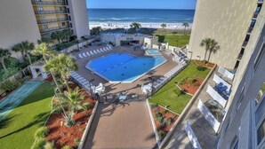 A pool area with a view of the beach, surrounded by buildings. - Beautiful Beachfront Studio with Beach Chairs for 2 (Panama City Beach)