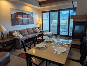 Una sala de estar con un sofá, una mesa de comedor para cuatro personas y una chimenea.