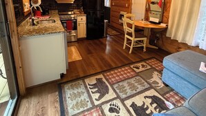 A cozy cabin interior with a kitchen, dining area, and a television. - WATER FRONT CABIN FOR COUPLES! (Butler)
