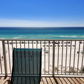 A balcony with a view of a beach, featuring sun loungers and umbrellas. - Your perfect vacation starts here in Princess 301! (Panama City Beach)