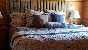 A wooden bed with patterned bedding and multiple pillows. - Time for hiking, fishing, boating  or just relaxing!  A great CO experience! (Pagosa Springs)