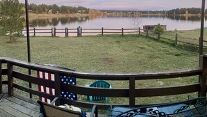 A lakeside deck with a view of a calm lake, surrounded by trees and a wooden fence. - Time for hiking, fishing, boating  or just relaxing!  A great CO experience! (Pagosa Springs)