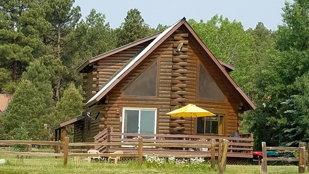 A log cabin with a porch and a yellow umbrella. - Time for hiking, fishing, boating  or just relaxing!  A great CO experience! (Pagosa Springs)