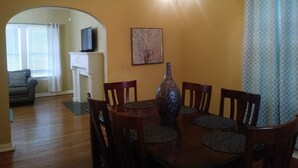 A dining area with a wooden table, chairs, a vase, and a painting on the wall. - CHARMING-Historic,Trinity University,Pearl Brewery, ONLY 3 miles to DT&Riverwalk (San Antonio)