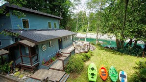 Ein Haus mit Terrasse, einer kleinen Veranda und Blick auf einen Strand.