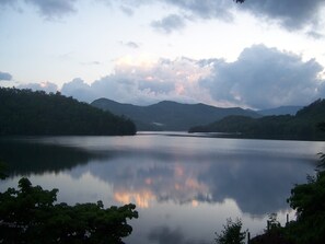 Ein ruhiger See mit umliegenden Hügeln und Bäumen.