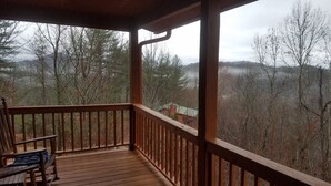 Una terraza de madera con vistas a un paisaje boscoso.