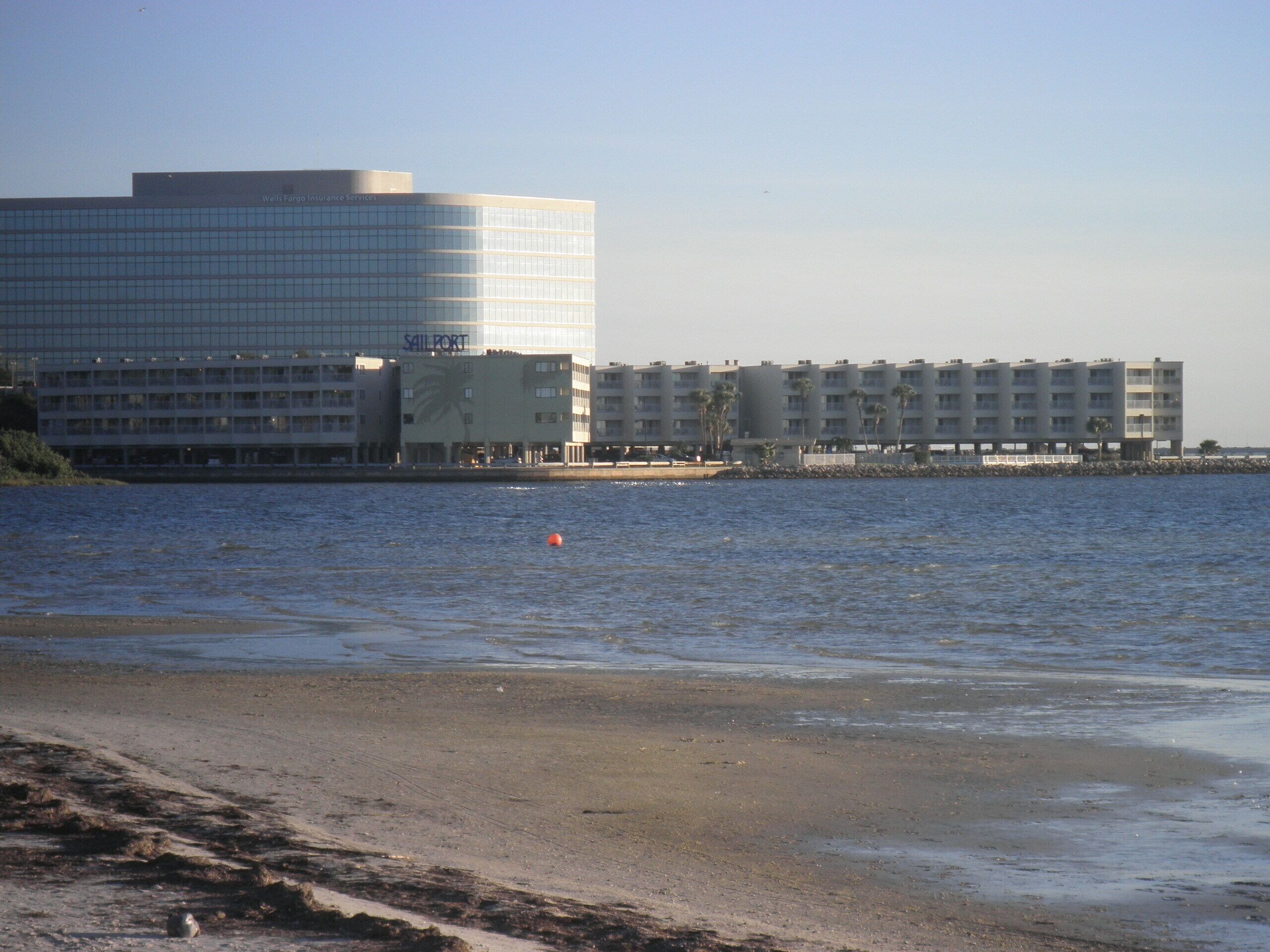 A waterfront hotel with multiple buildings, including a large office building and several residential units.