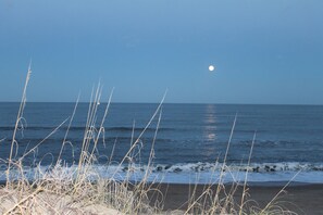 A beach with the ocean and a visible moon in the sky. - Oceanfront property (Duck)