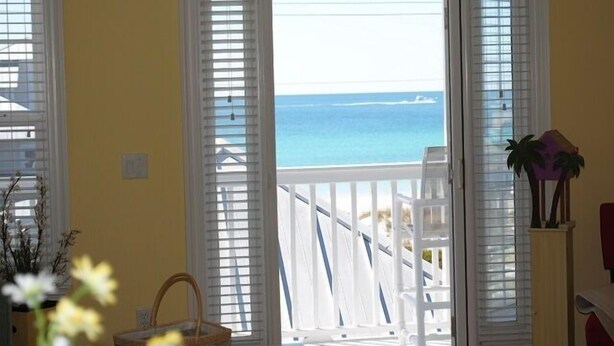 Una stanza con vista sull'oceano, da un balcone con ringhiere bianche.