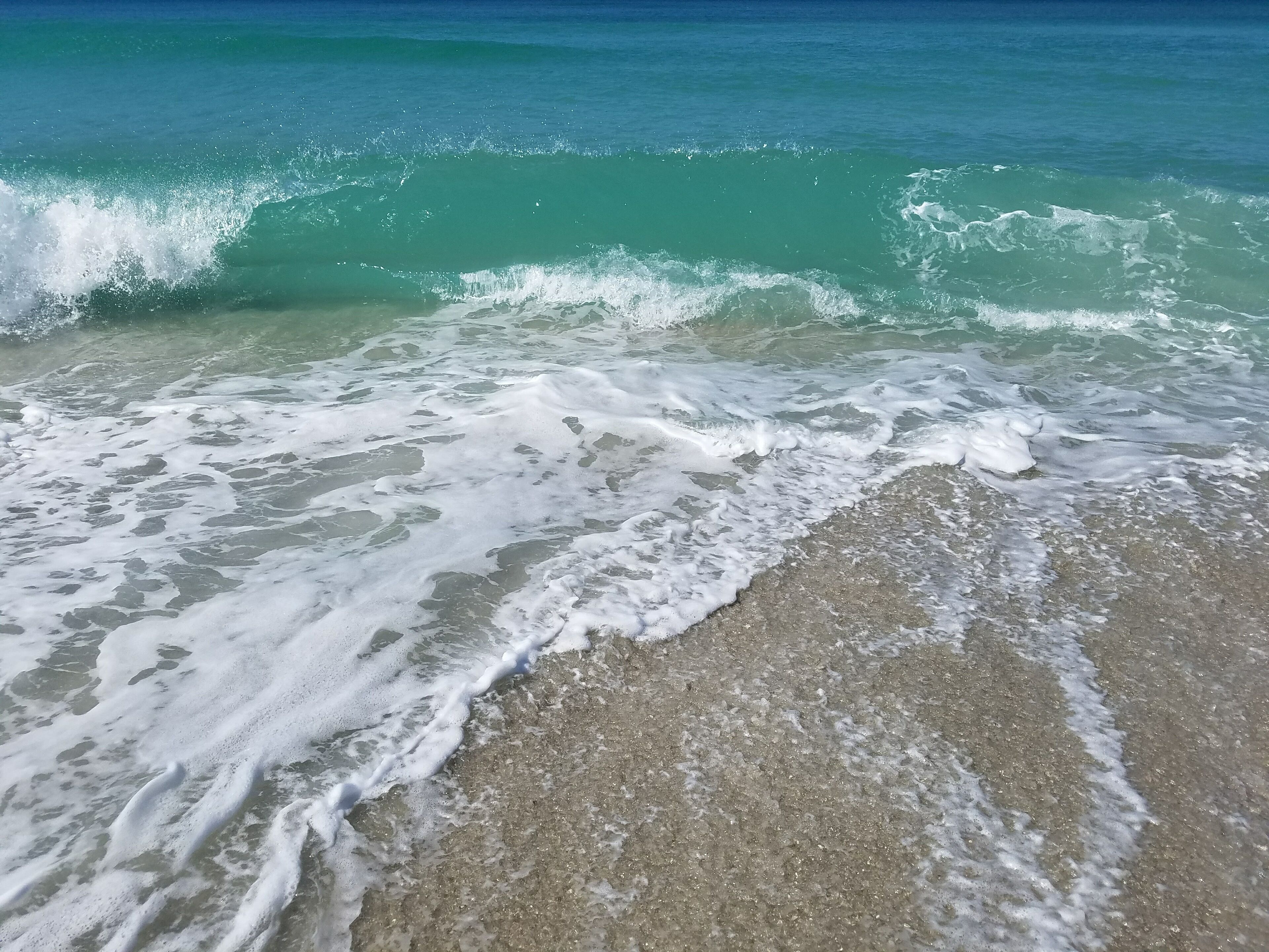 A beach with waves crashing onto the shore.