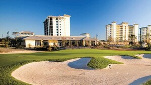 Un campo da golf con bunker di sabbia e un edificio sullo sfondo.