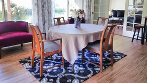 A dining area with a round table, chairs, and a floral centerpiece.