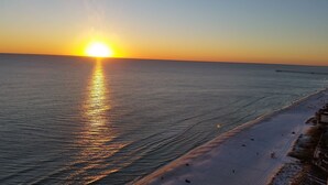 A beach at sunset with a pier extending into the water. - TOP FLOOR, GREAT VIEW, FRIENDLY PRICES! (Panama City Beach)
