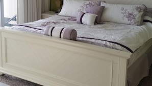A bedroom with a bed, a ceiling fan, a clock, and two framed pictures on the wall. - TOP FLOOR, GREAT VIEW, FRIENDLY PRICES! (Panama City Beach)