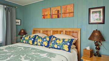 A bedroom with a bed, a nightstand, a lamp, and wall art.