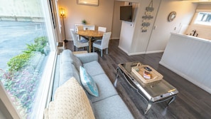 Un salon moderne comprenant un canapé, une table basse et un coin repas avec une table et des chaises.