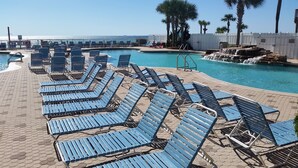A pool area with blue lounge chairs and a small waterfall feature. - JUST LISTED, OPEN CALENDAR, FRIENDLY PRICES (Panama City Beach)