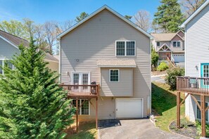 A two-story house with a front deck, a garage, and a small porch.