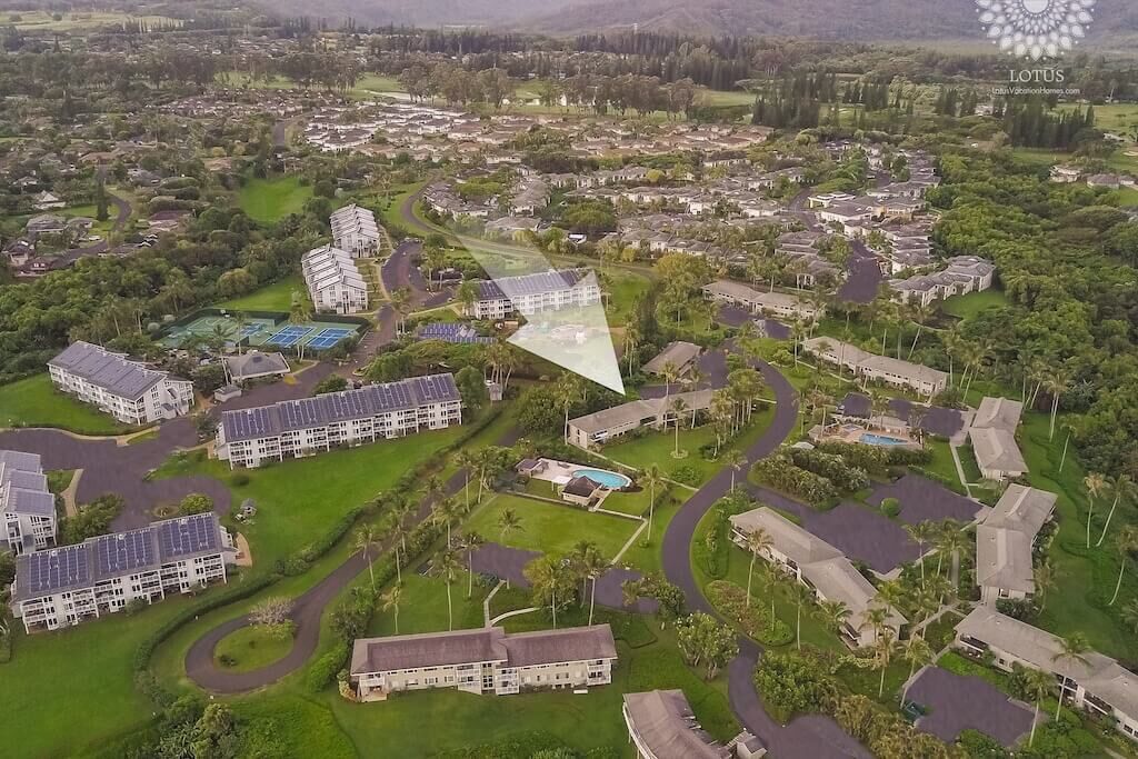 Vista aérea de una zona residencial con varios edificios, carreteras y espacios verdes.