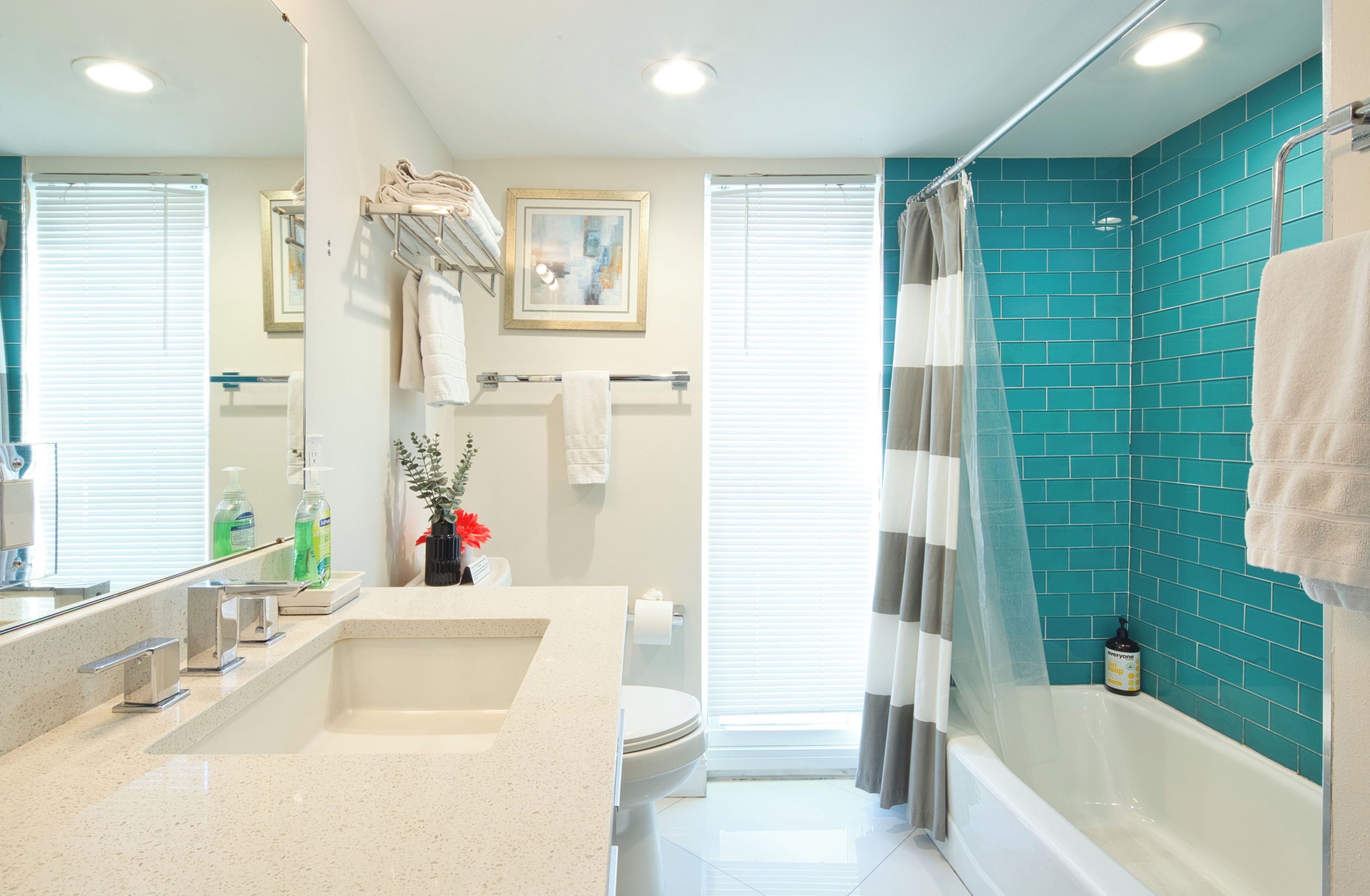 A modern bathroom with a large sink, toilet, and shower area.