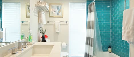 A modern bathroom with a large sink, toilet, and shower area.