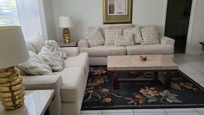 Relax in this inviting living space with a beige sofa, armchair, and coffee table.