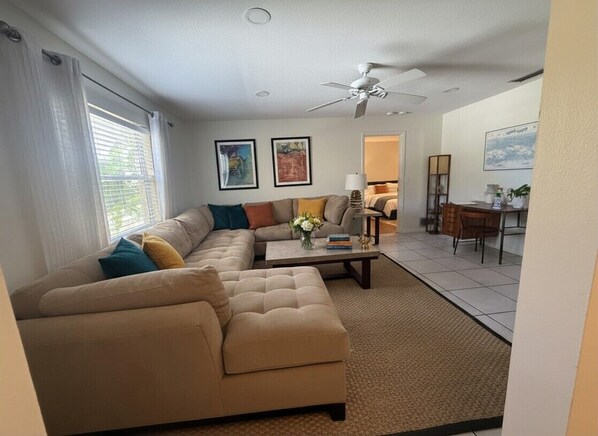 A living room with a sofa, a coffee table, and a ceiling fan.