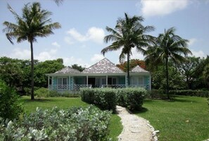 Surrounded by lush greenery and palm trees, this charming abode offers a tranquil retreat.