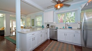 A modern kitchen with white cabinetry, a built-in dishwasher, and a ceiling fan. - Beautiful Clearwater Beach Home just across from the Beach - Drive to your door. (Clearwater Beach)