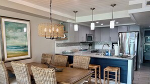 Una cocina moderna con una isla central, armarios grises y una lámpara colgante.