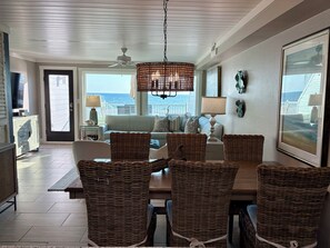 Relax in this stylish living room with a high ceiling, fan, and ocean views.