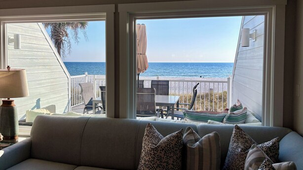 Un salón acogedor con un amplio ventanal con vistas a la playa.