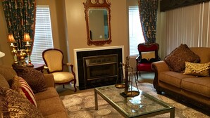 Un salon avec une cheminée, deux canapés, une table basse et un miroir.