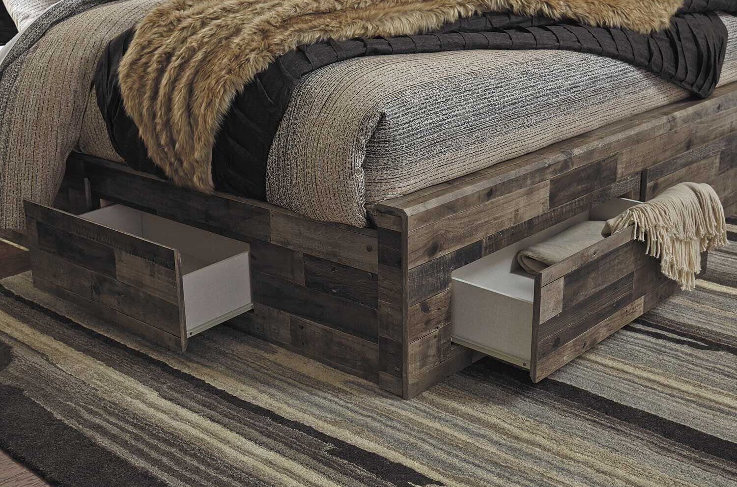 Un letto con struttura in legno, due cassetti e una coperta.