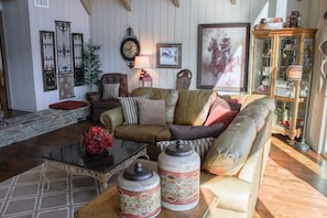 A cozy living room with a brown leather sofa, a glass coffee table, and decorative jars. - Breathtaking Lake Views from every room! (Lake Arrowhead)