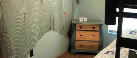 A bedroom with a bunk bed, a dresser, and a wall with a life quote.