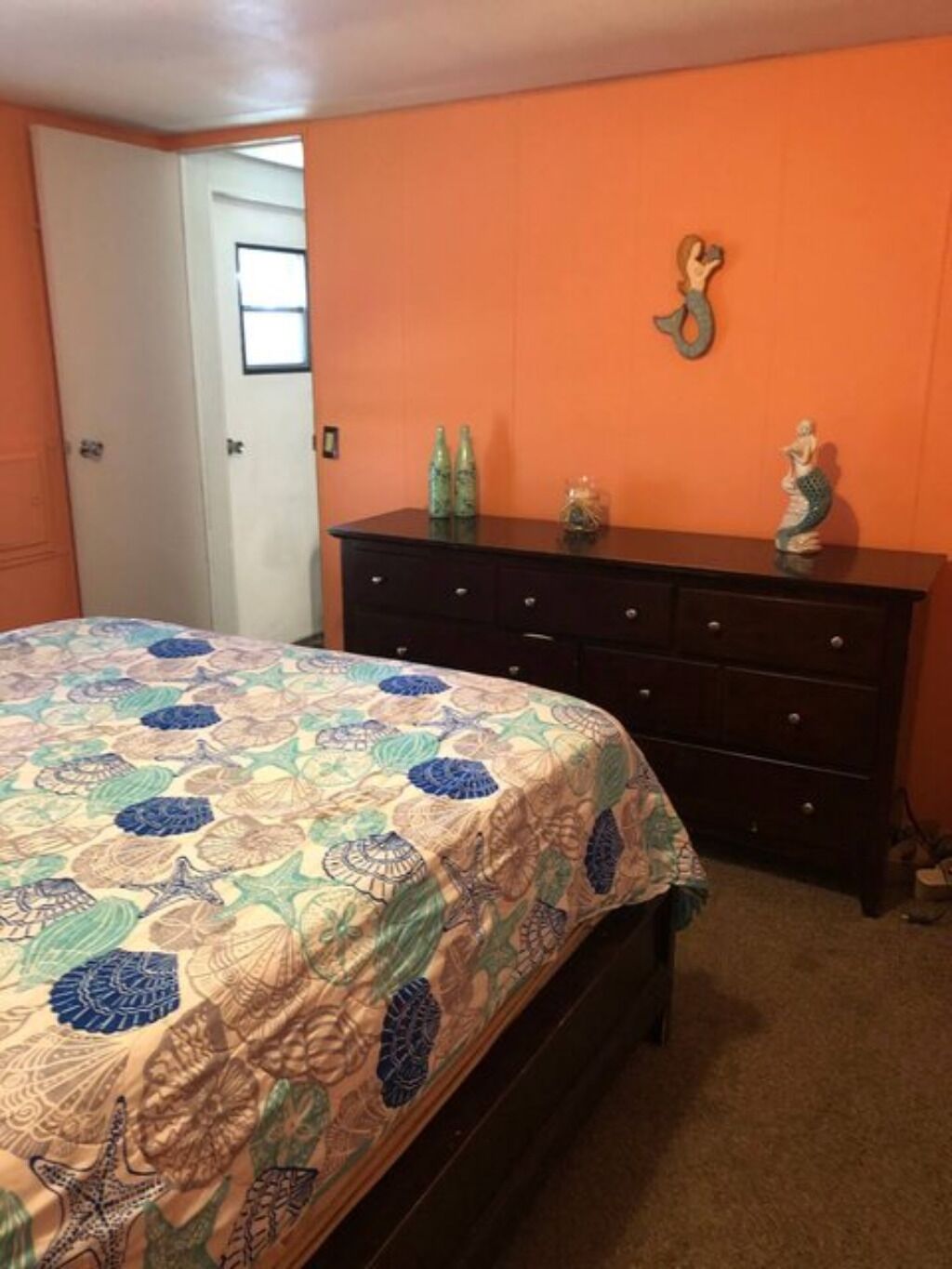 Un dormitorio con cama, cómoda y puerta.