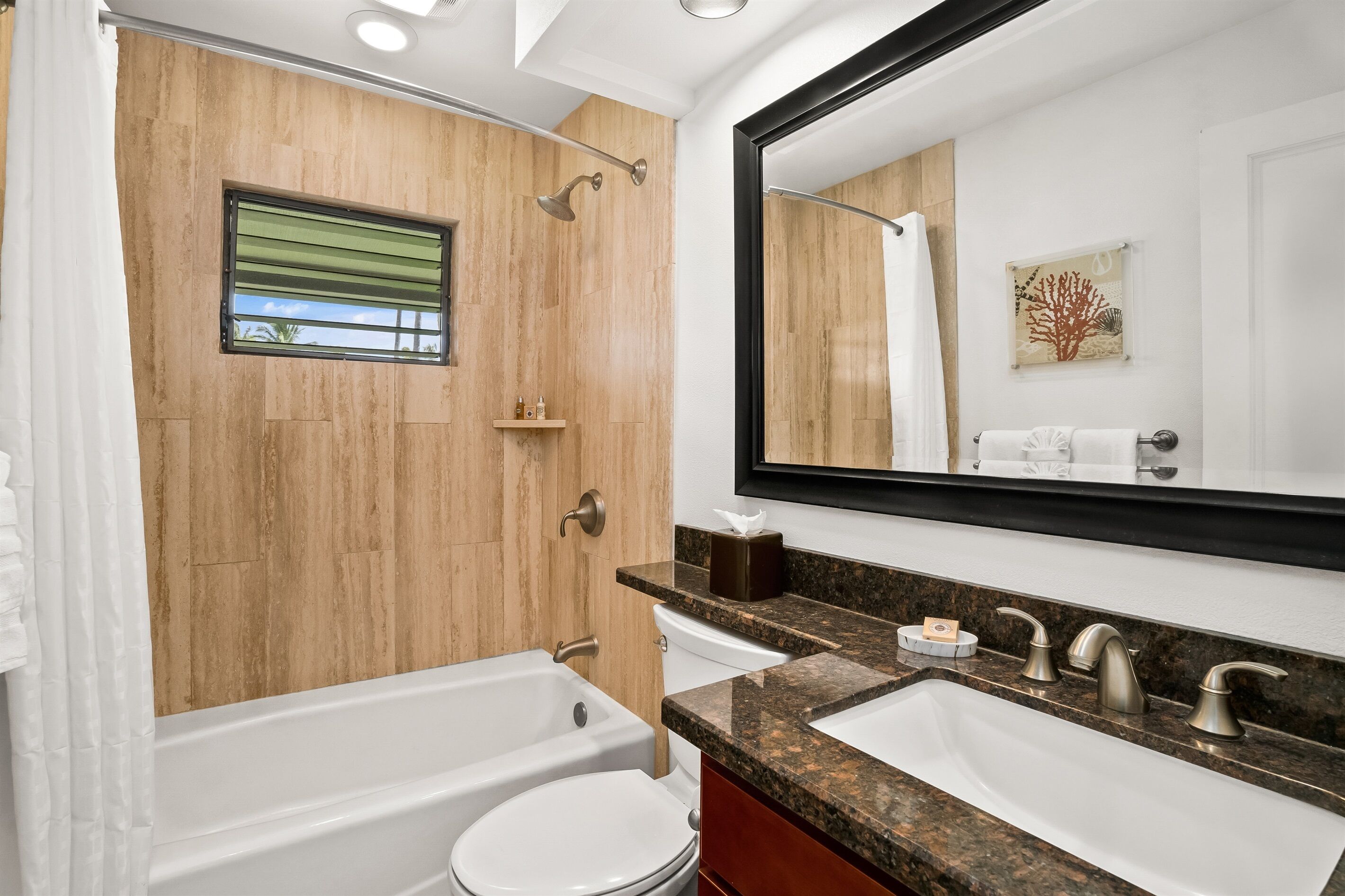 A modern bathroom with a bathtub, toilet, and sink.
