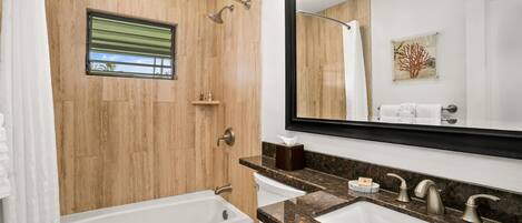 A modern bathroom with a bathtub, toilet, and sink.