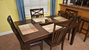A dining table set with placemats, chairs, and a centerpiece.