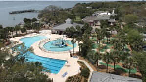 Un resort con una gran piscina, un tobogán de agua y vista al océano.