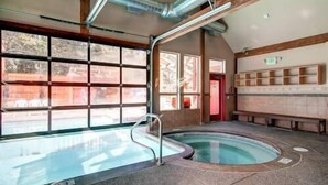 A swimming pool with a glass enclosure, wooden beams, and a bench area. - Best Location in Town! Ski-in/Ski-out on Peak 9! (Breckenridge)