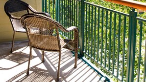 A balcony with wicker chairs, a green railing, and a view of trees. - Best Location in Town! Ski-in/Ski-out on Peak 9! (Breckenridge)