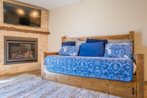 A bedroom with a bed, a TV mounted on the wall, and a fireplace. - Best Location in Town! Ski-in/Ski-out on Peak 9! (Breckenridge)