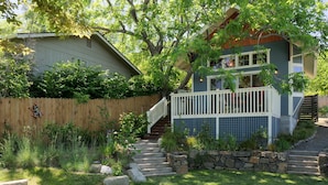 A two-story house with a wooden deck, stone steps, and a stone wall. - The Ashland Cottage, walk to town (Ashland)