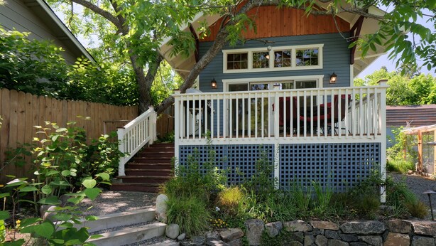 A house with a wooden deck, a stone wall, and a wooden fence. - The Ashland Cottage, walk to town (Ashland)