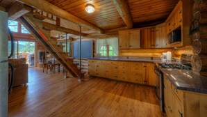 A spacious kitchen with wooden cabinets, a large island, and a built-in stove.