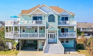 Une maison à deux étages située en bord de mer, dotée d’un balcon, d’une enseigne indiquant la présence d’un restaurant et du numéro « 3621 » sur la porte d’entrée.