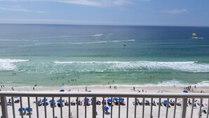 A beach with clear waters, people swimming and surfing, and numerous beach umbrellas. - GREAT VIEW, FRIENDLY PRICES! (Panama City Beach)